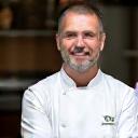 Portrait de Chef Antoine Dubois, nutritionniste culinaire, souriant dans une cuisine lumineuse.