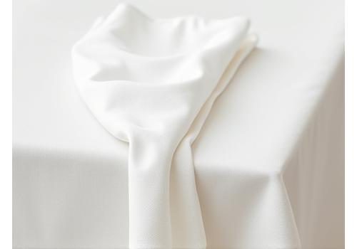 Détail de nappes et serviettes en lin blanc immaculé, parfaitement repassées et pliées, avec une texture riche et un léger reflet de lumière, créant une ambiance de pureté.